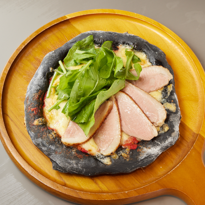 スタンドぱと梅田店の自家製鴨ハムとルッコラのピザ